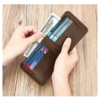 Man holding a dark brown men's wallet with cash