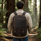 Man wearing the leather commuter backpack in a forest