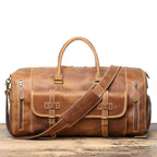 Man carrying the brown leather gym bag on a mountain trail