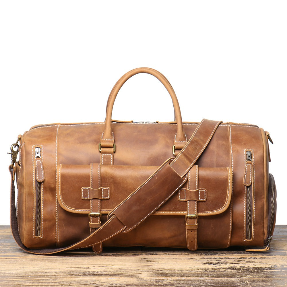 Man carrying the brown leather gym bag on a mountain trail