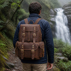 Man wearing the leather knapsack near a waterfall