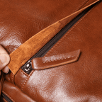 Brown men's laptop backpack, front pocket detail