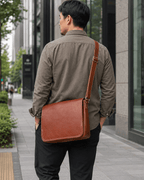 Man wearing the brown leather messenger bag, back