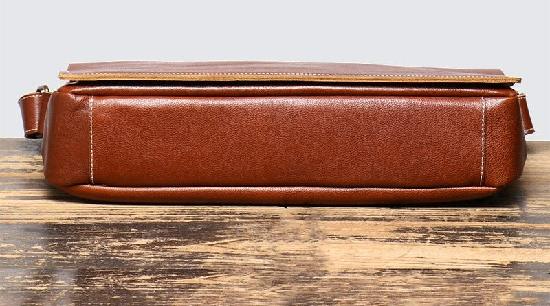 Brown men's messenger bag, zip pocket and strap detail