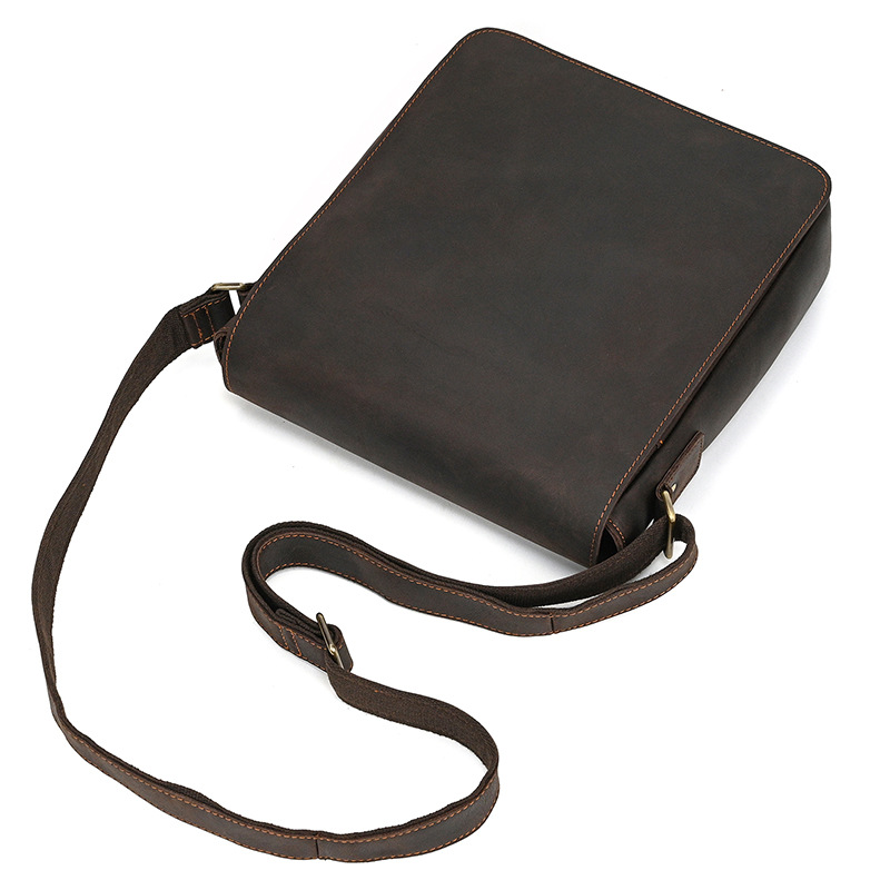 Brown-black men's messenger bag, flat lay