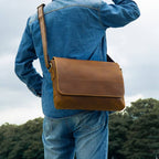 Man wearing the brown leather messenger bag, denim jacket