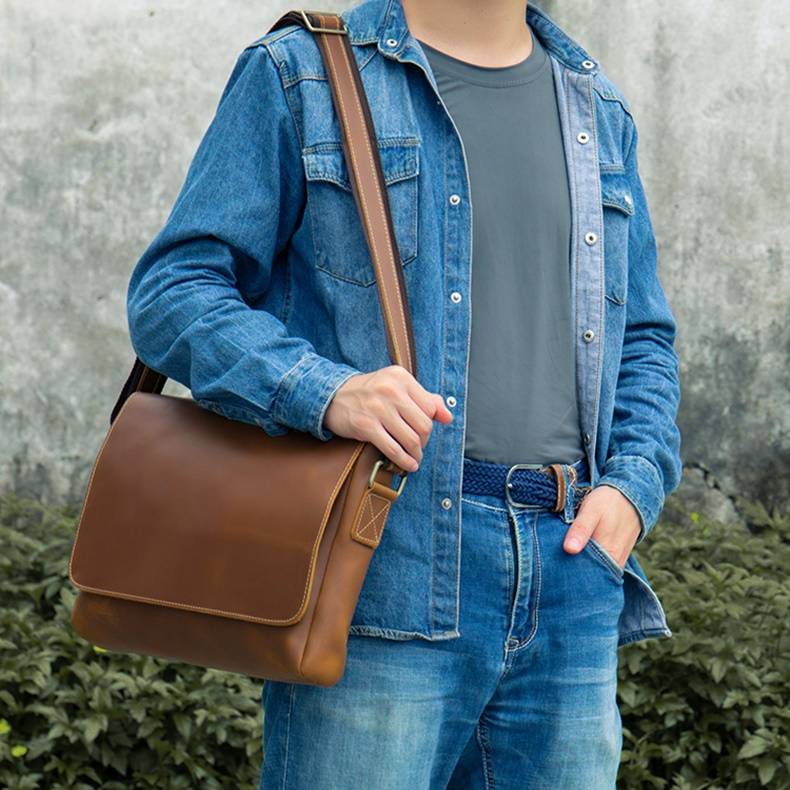 Man wearing the brown leather messenger bag, front