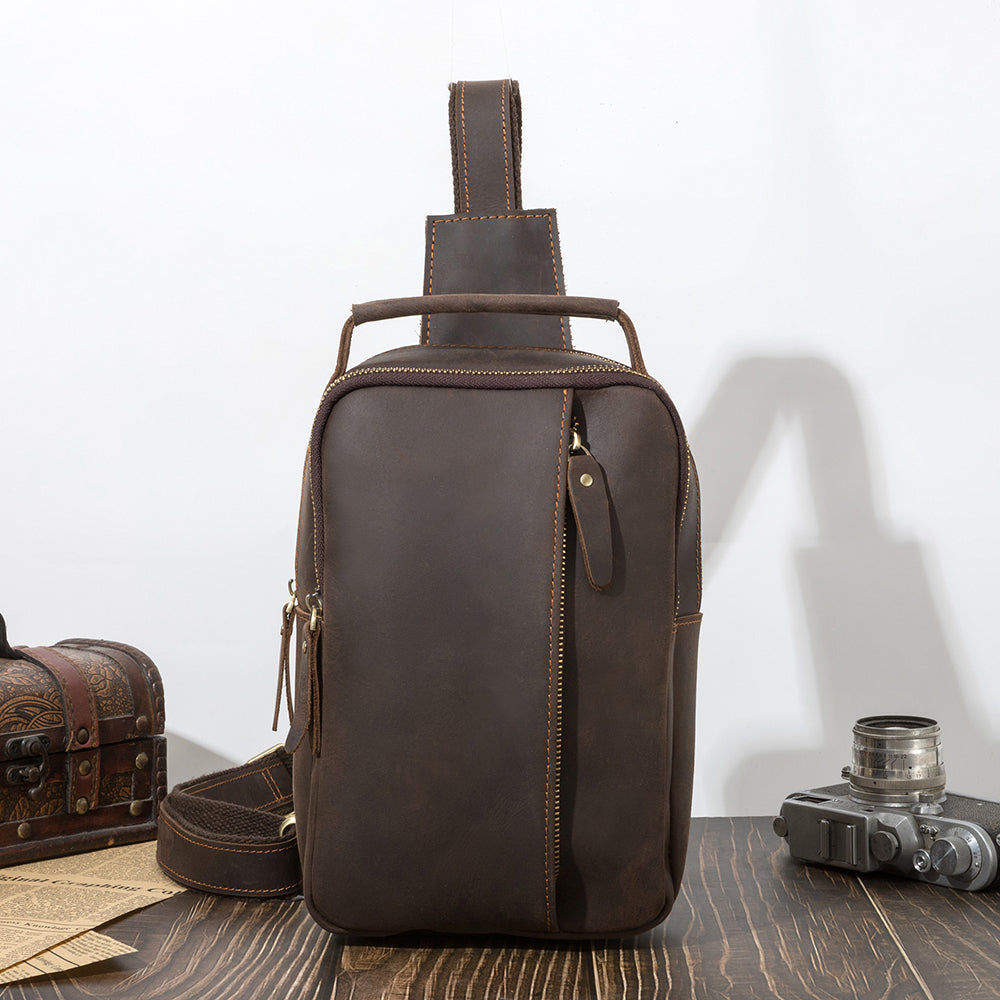 Dark brown men's sling backpack, top handle detail