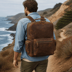 Man wearing the leather weekender backpack on a coastal trail